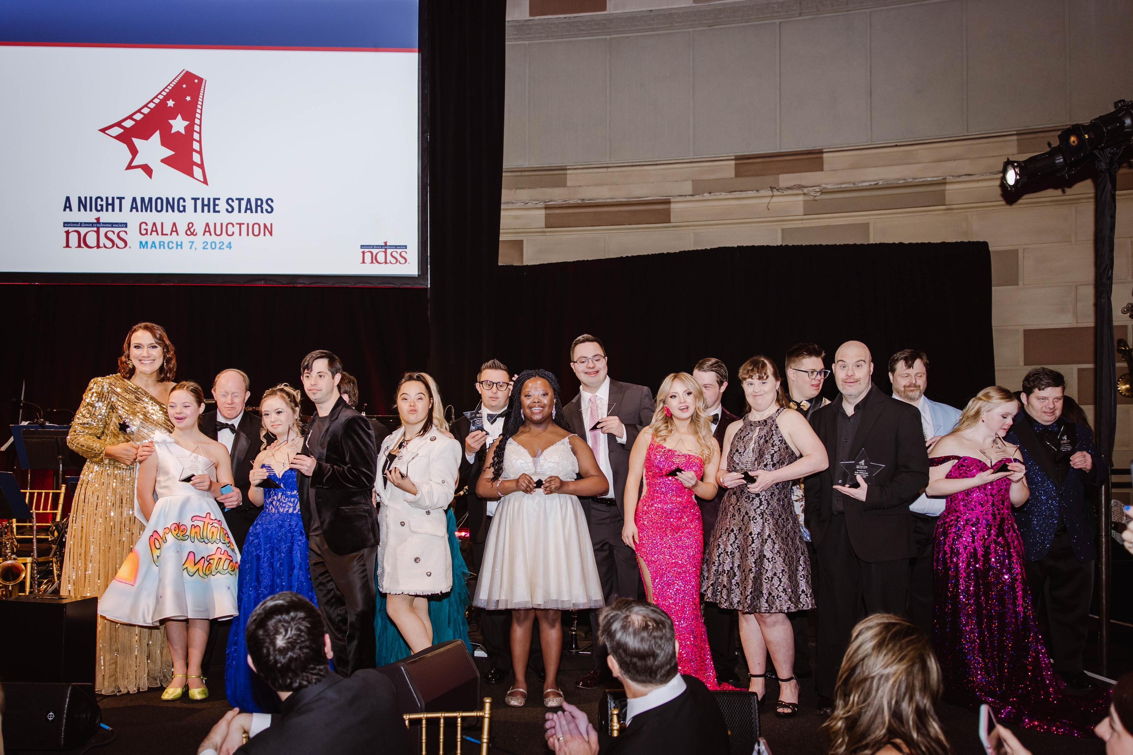 group of individuals with Down syndrome (18 people) honored on stage at NDSS gala
