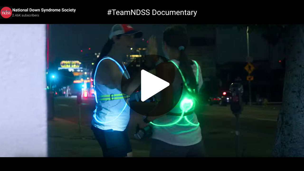 #TeamNDSS Documentary. Screenshot of a video with two runners wearing bright lights in the dark. 