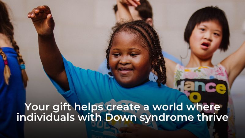 Your gift helps create a world where individuals with Down syndrome thrive. Image of two kids with Down syndrome dancing