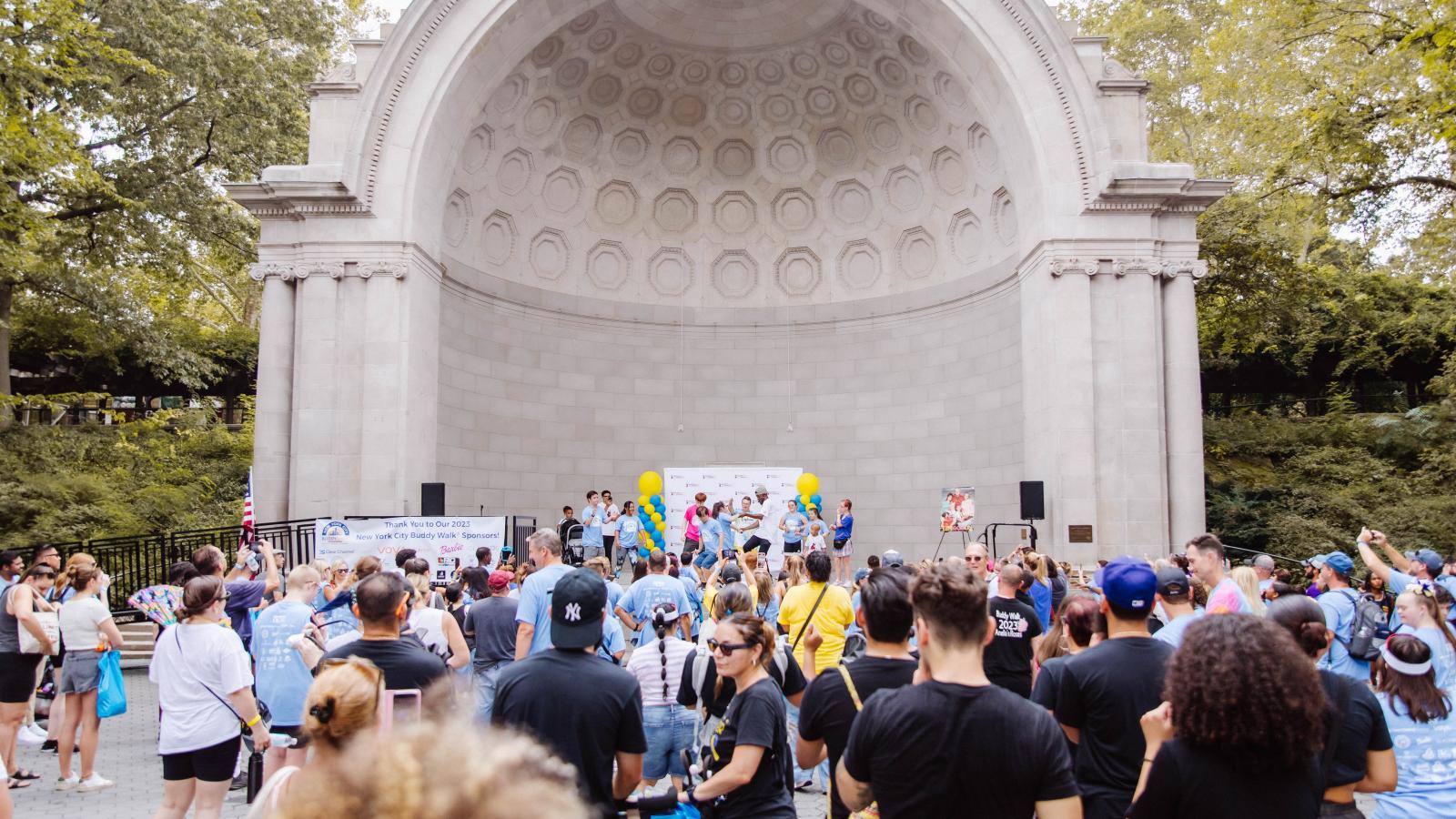 photo of a crowd at the Central Park Bandshell, a large dome-shaped stage structure