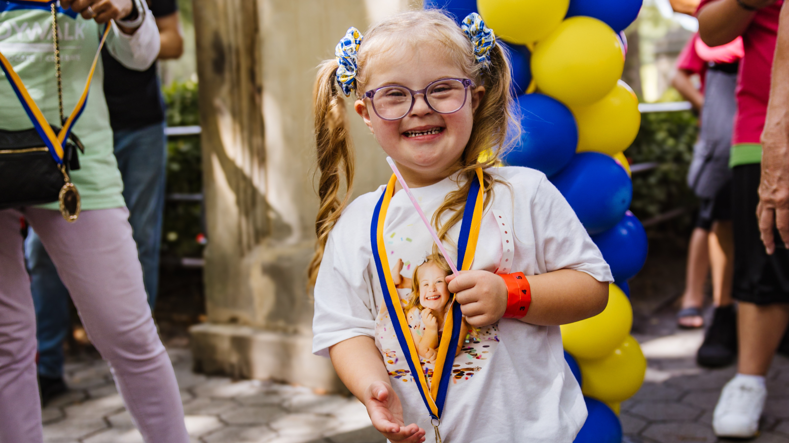 Girl with Down syndrome and pig tails crossed the Buddy Walk finish line