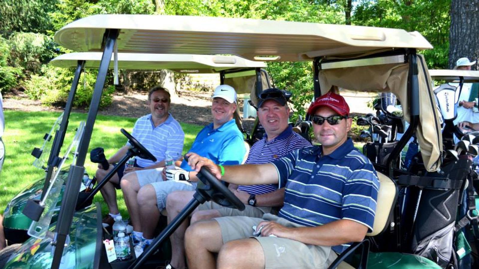 Four men drive two golf carts