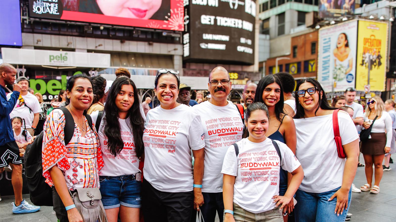 A family wearing Buddy Walk t-shirts smiles for the camera at Times Square