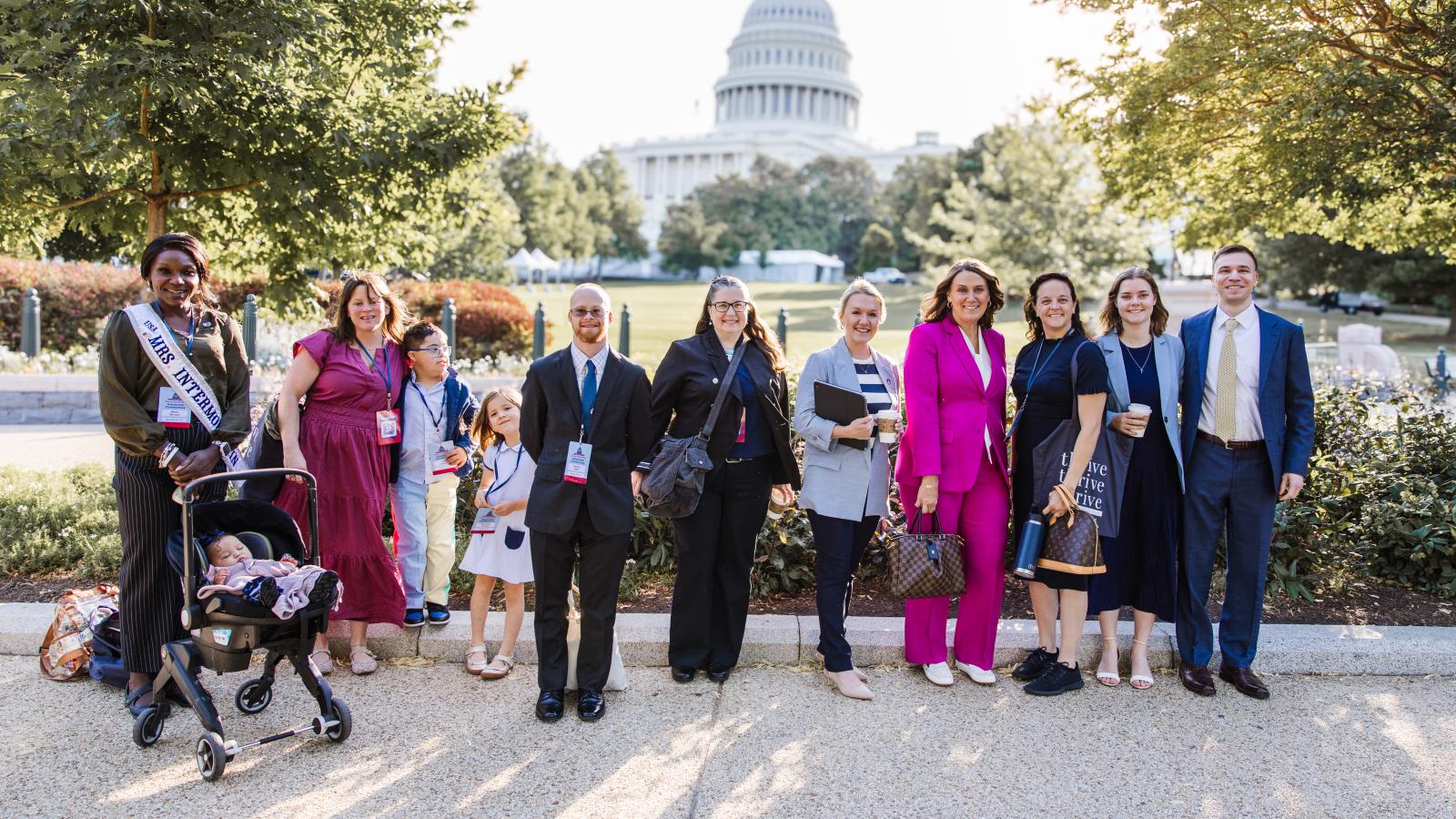 A group of advocates with and without Down syndrome pose in front of the U.S. Capitol Building