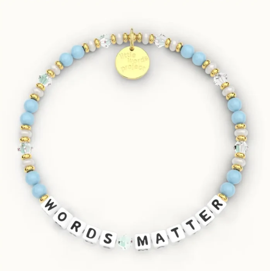 Image of a blue and white bracelet. Beads spell out, "Words Matter". A large gold bead at the bottom of the bracelet says, "Little Words Project"