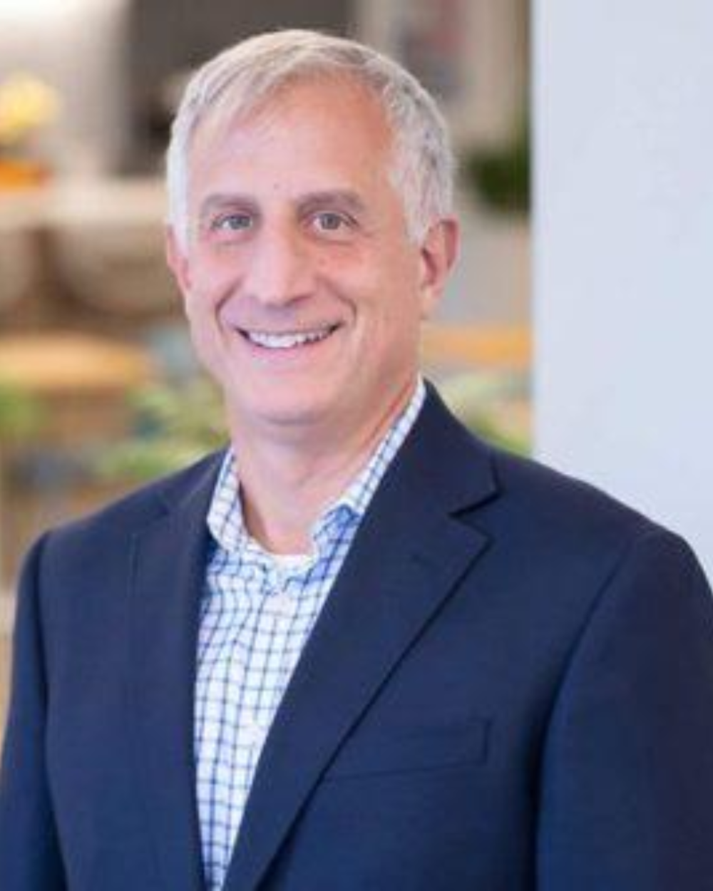 Headshot of Anthony Providenti, a man with white hair, wearing a light checkered collar shirt and black suit jacket.