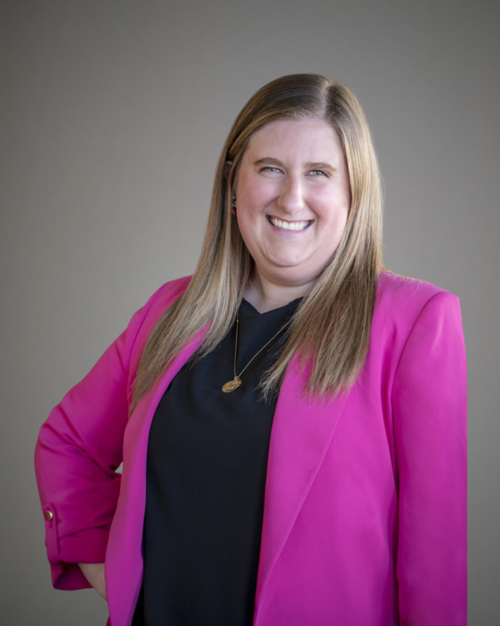 Headshot of Colleen Hatcher, a woman with blonde hair, wearing a black blouse and a bright pink blazer.
