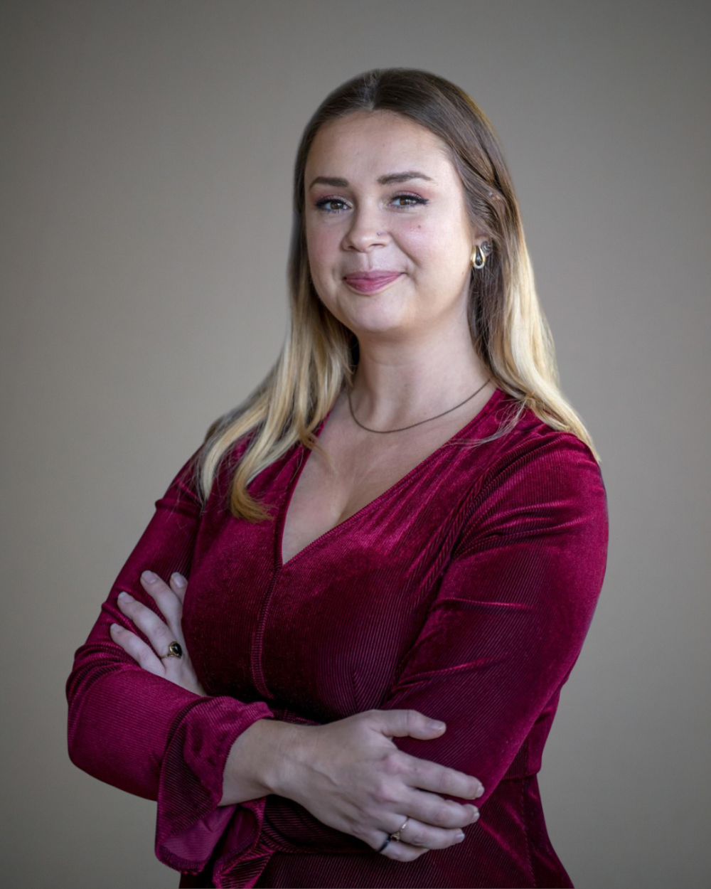 Headshot of Emily Ingmire, a woman with brown and blonde hair, wearing a red velvet blouse.