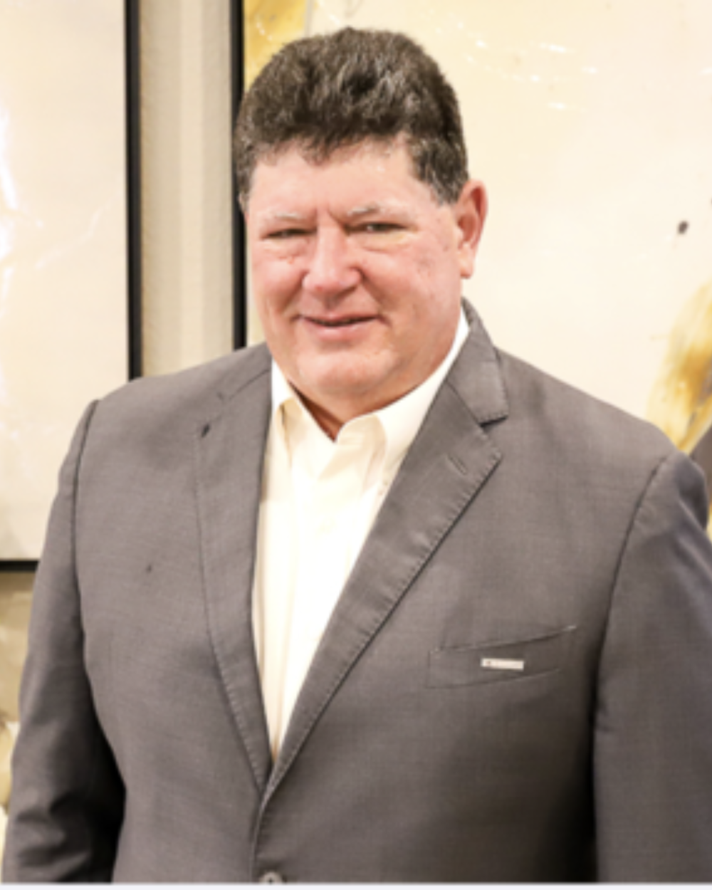 Photo of Joe Joyce, a man with grey hair, wearing a white collar shirt and a grey suit jacket.