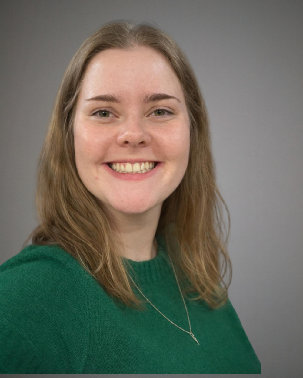 Headshot of Katrina Schultz, a woman with light brown hair, wearing a green sweater.