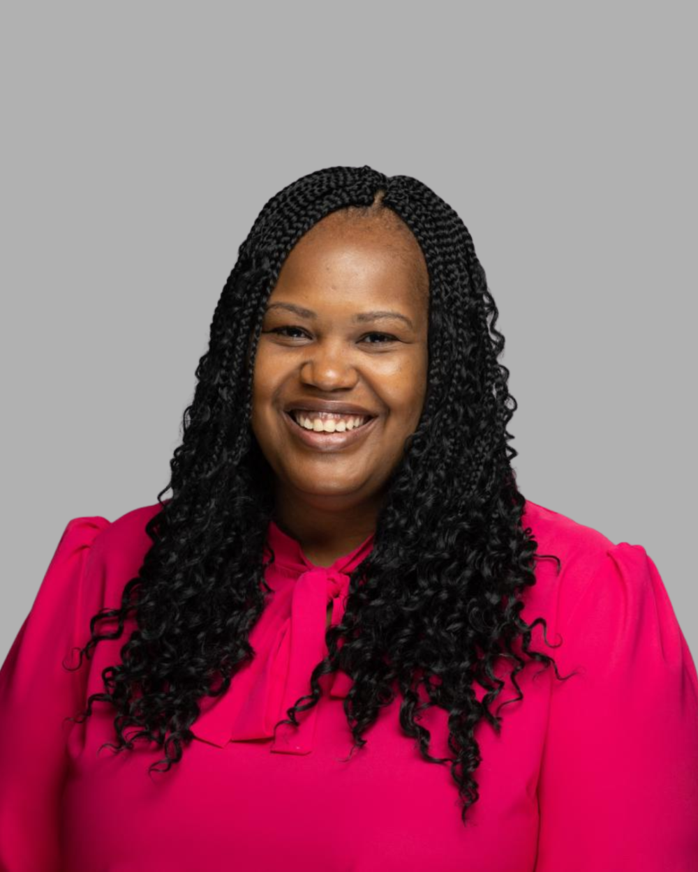Headshot of Marjorie C. Shavers, a woman with black hair wearing a bright pink blouse.