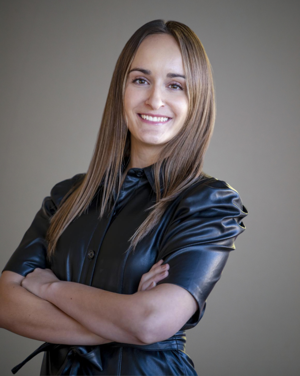 Headshot of Michelle Sagan, a woman with brown hair, wearing a black dress.