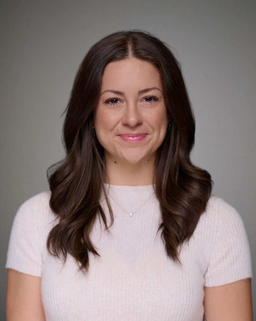 Headshot of Genevieve Thompson, a woman with brown hair, wearing a white, knit shirt.