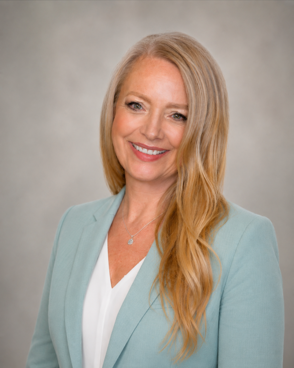 Headshot of Janice Fountaine, a woman with light blonde hair, wearing a white blouse and a light blue blazer.
