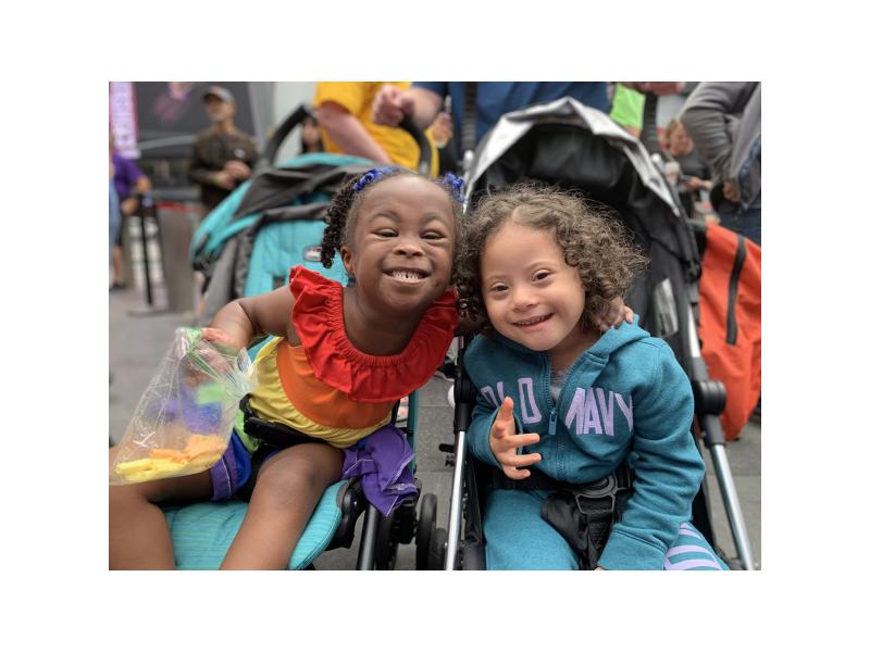 toddlers with Down syndrome hugging and smiling at the camera