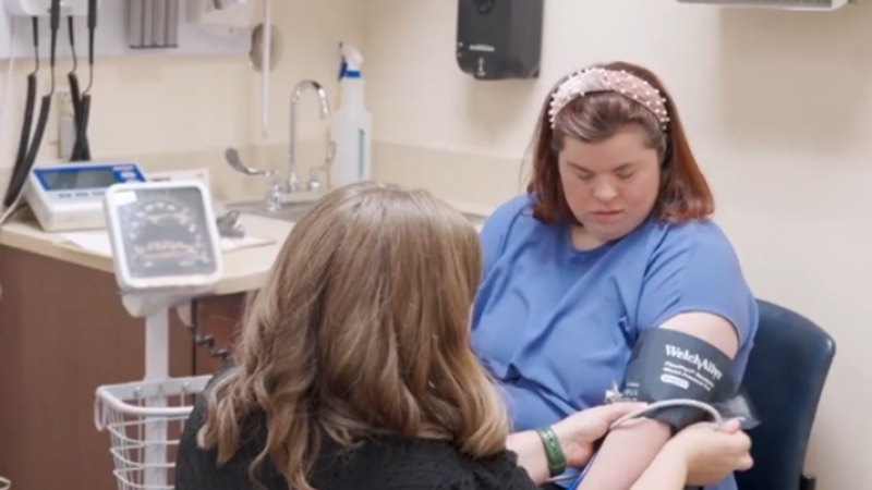 A woman with Down syndrome has her blood pressure read.