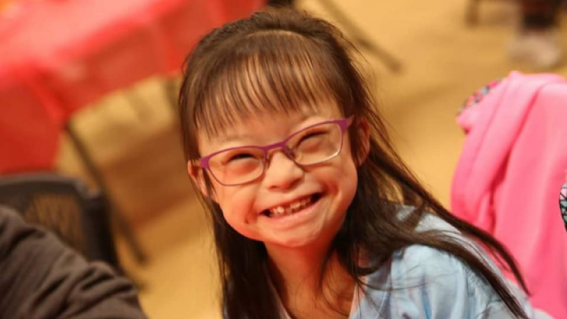 young girl with down syndrome smiling