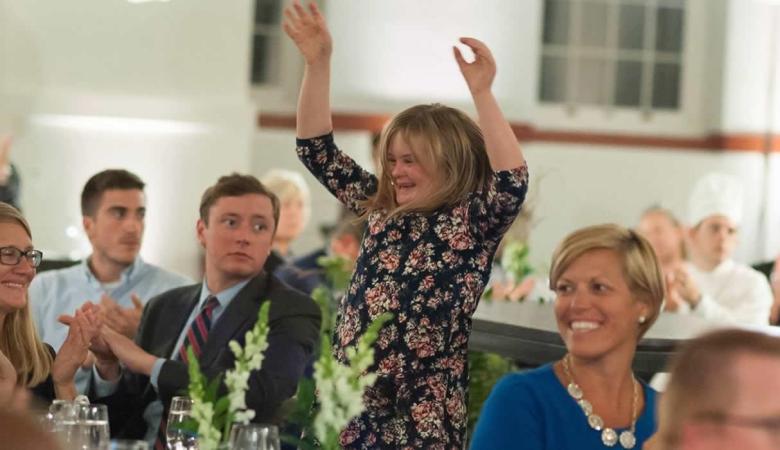 Girl with Down syndrome celebrating in a group