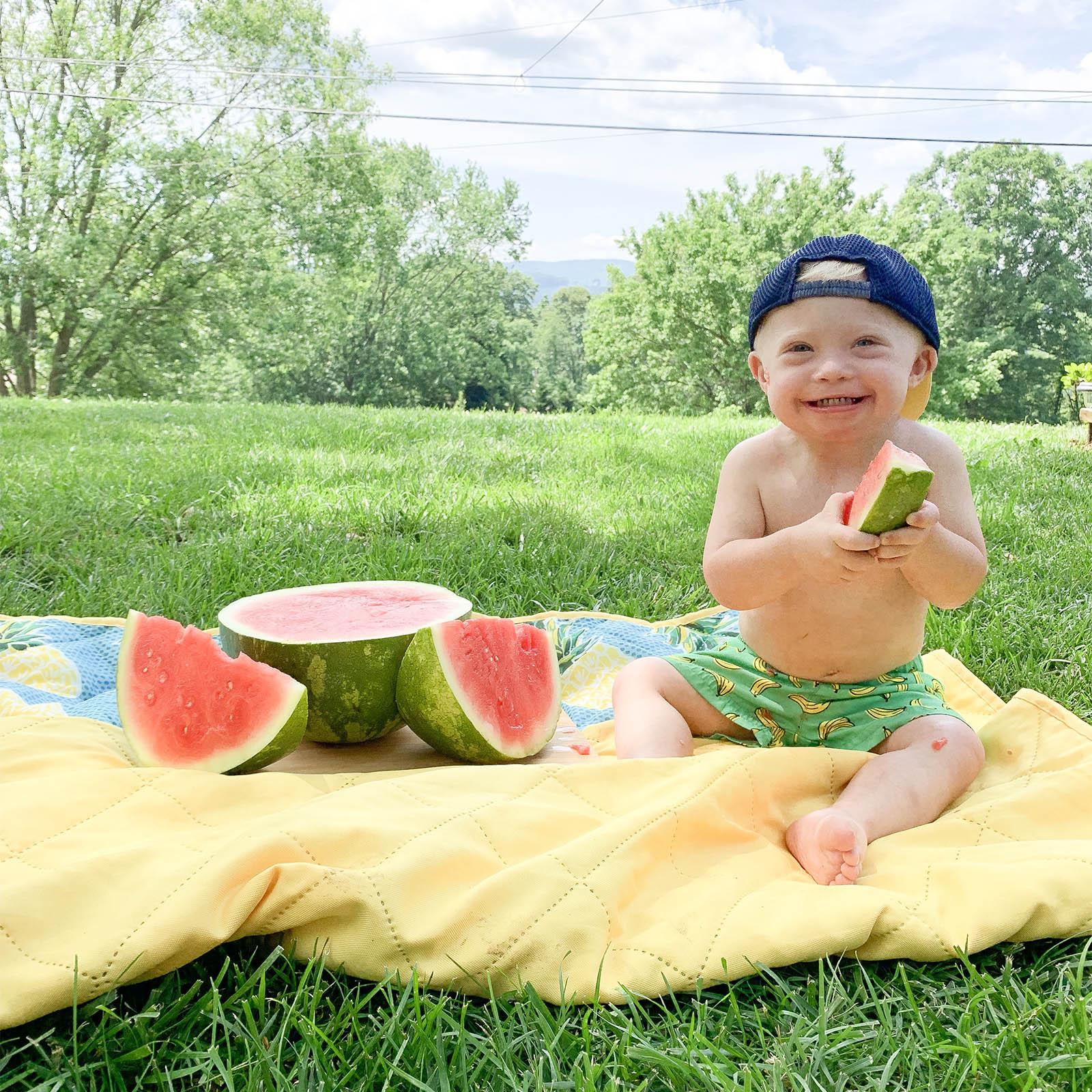 Young boy with down syndrome eating watermelons