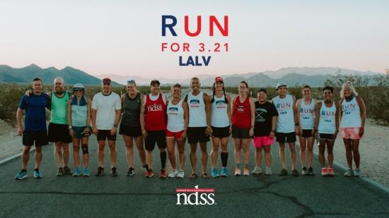 team of runners in a line smiling at the camera
