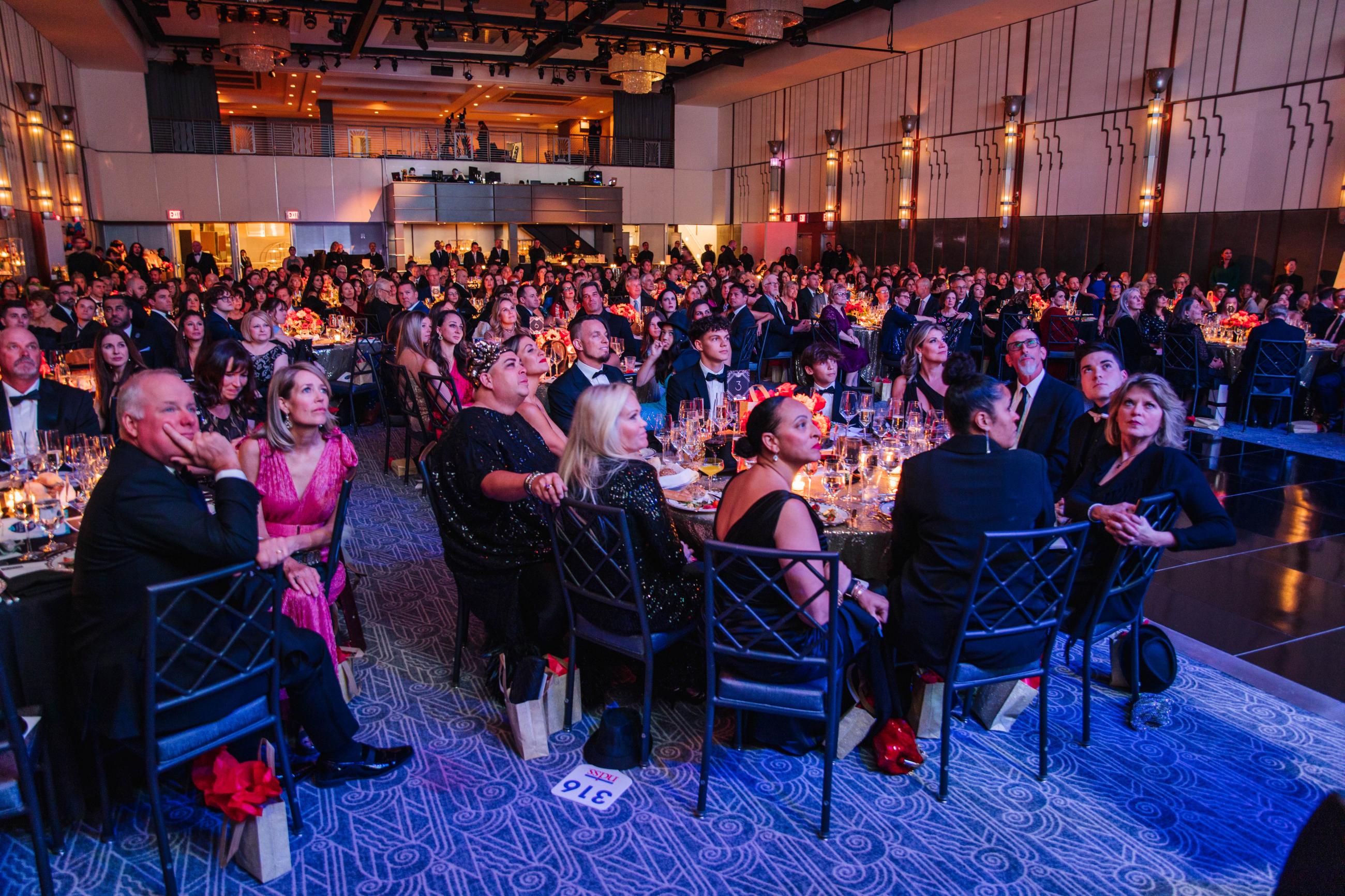 full room shot of the 2023 NDSS gala with attendees sitting at their tables watching the speaker