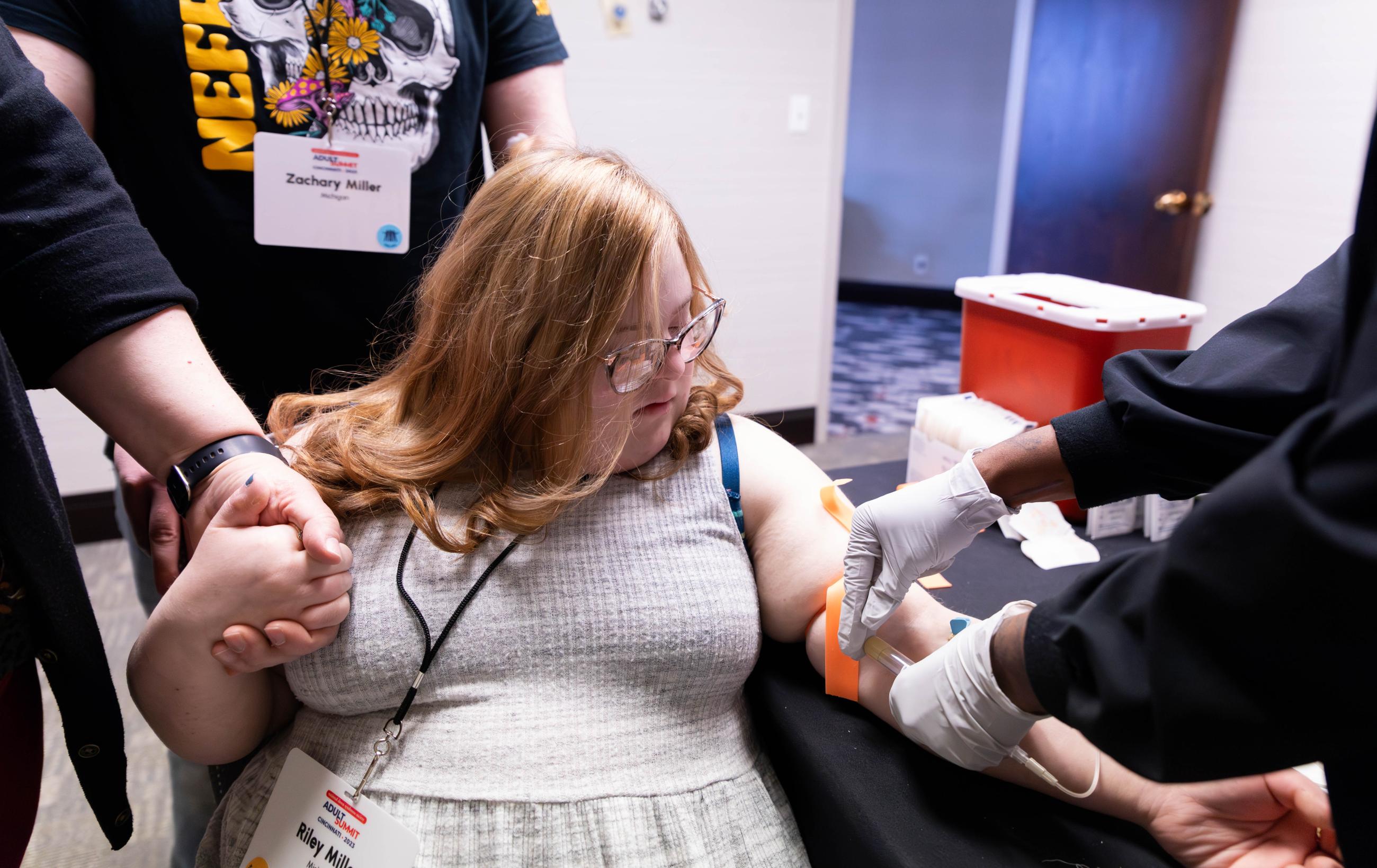 Woman with Down syndrome receives a blood test at the doctor's office