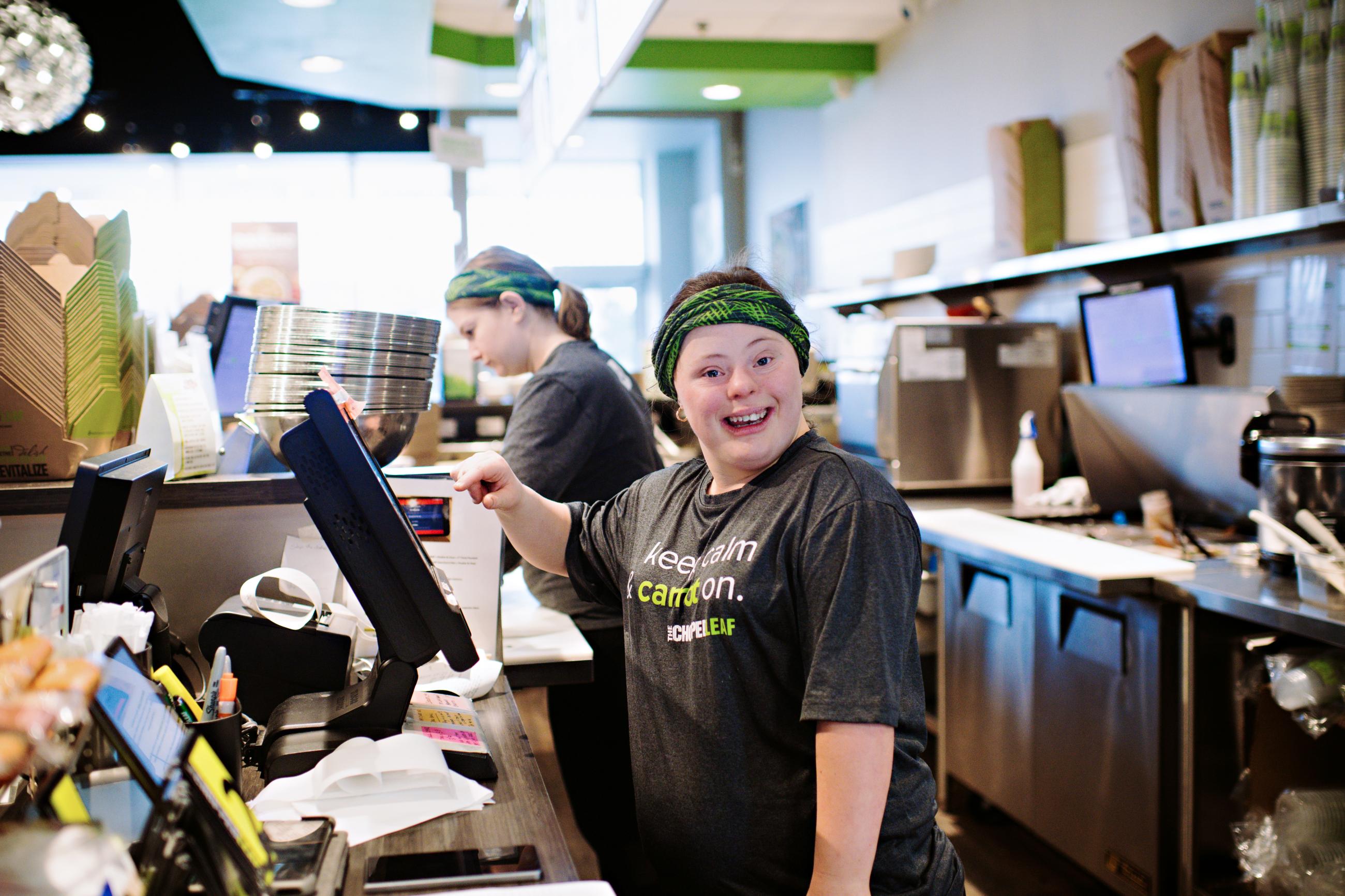 A woman with Down syndrome operates a cash register