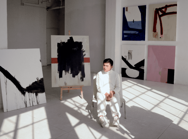 Young man with Down syndrome showing his paintings