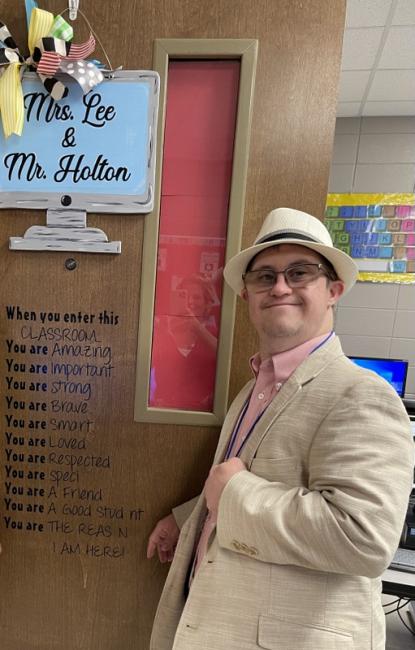 Michael Holton posing in front of his classroom