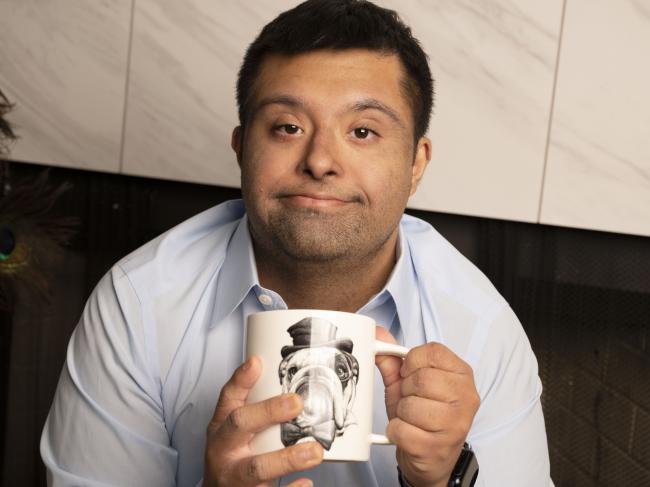 man with down syndrome holds tea mug