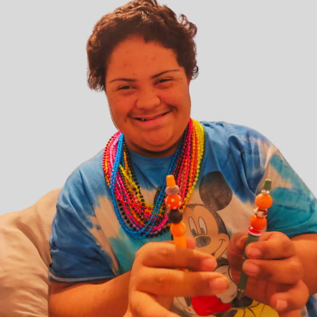 Jeremiah Collier, a man with Down syndrome, holds his beaded pens.