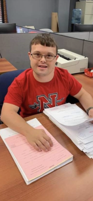 Sean Adams, a man with Down syndrome, does paperwork