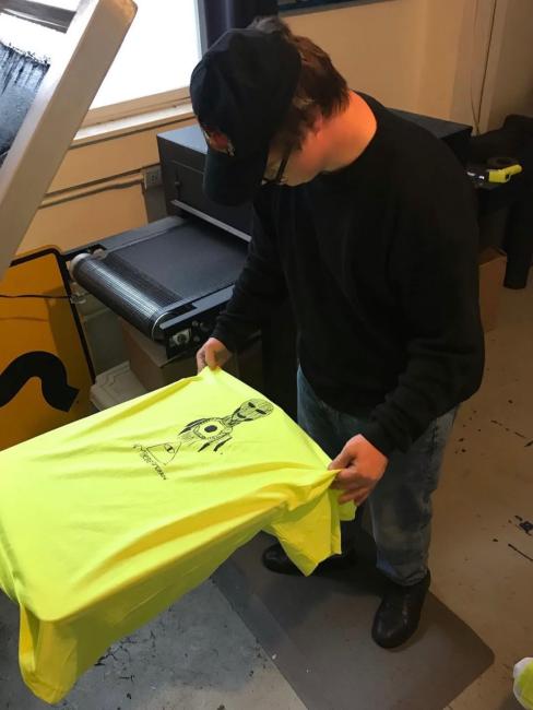 Dan Harvis Holland, a man with Down syndrome, prints a t-shirt with his artwork.