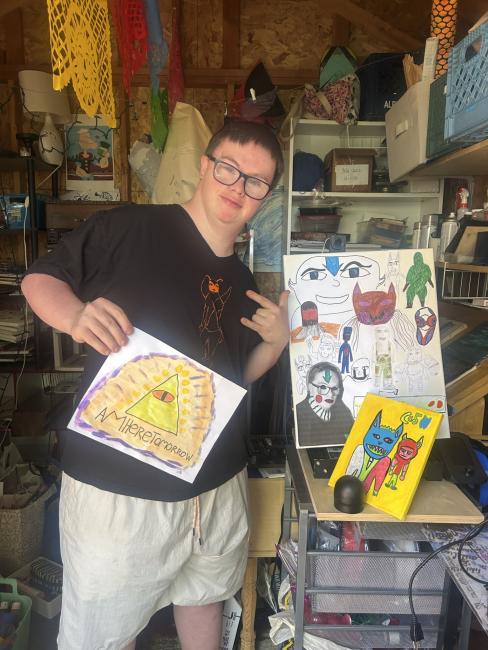 Dan Harvis Holland, a man with Down syndrome, holds his artwork.
