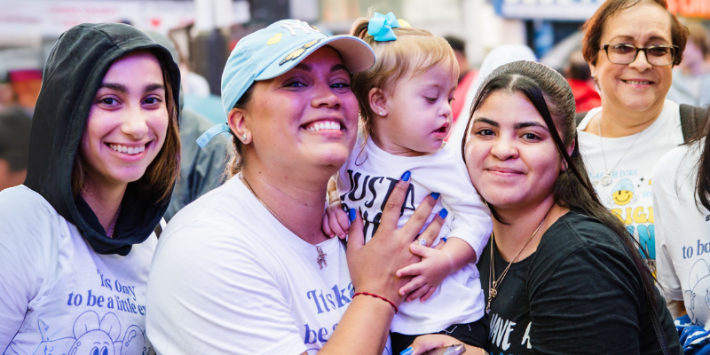 Family with a baby with Down syndrome smiles at Times Square